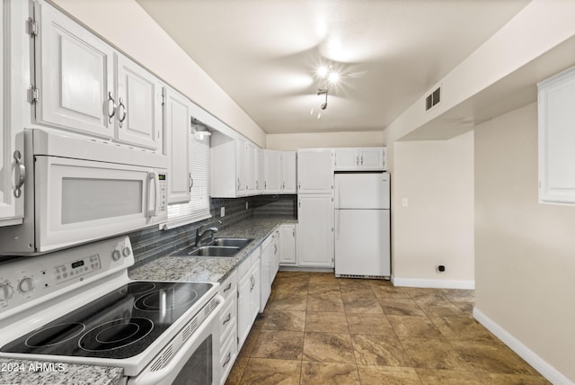 kitchen with light stone counters, tasteful backsplash, white cabinets, white appliances, and sink