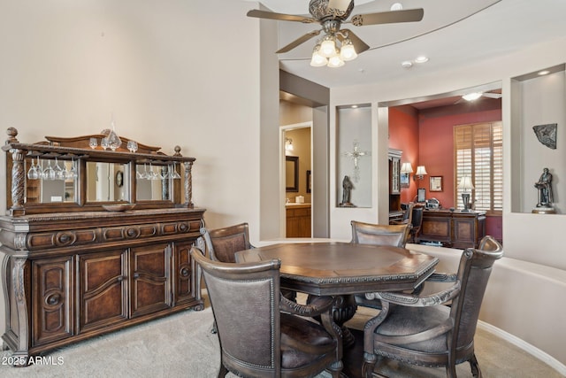 carpeted dining room with ceiling fan