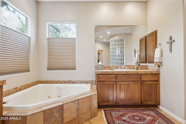 bathroom featuring vanity and tiled tub