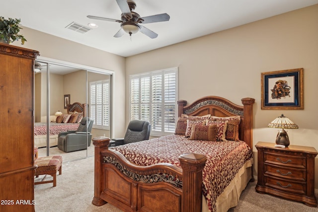 bedroom with light colored carpet, ceiling fan, and a closet