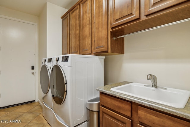 clothes washing area featuring cabinets, light tile patterned flooring, sink, and washing machine and clothes dryer