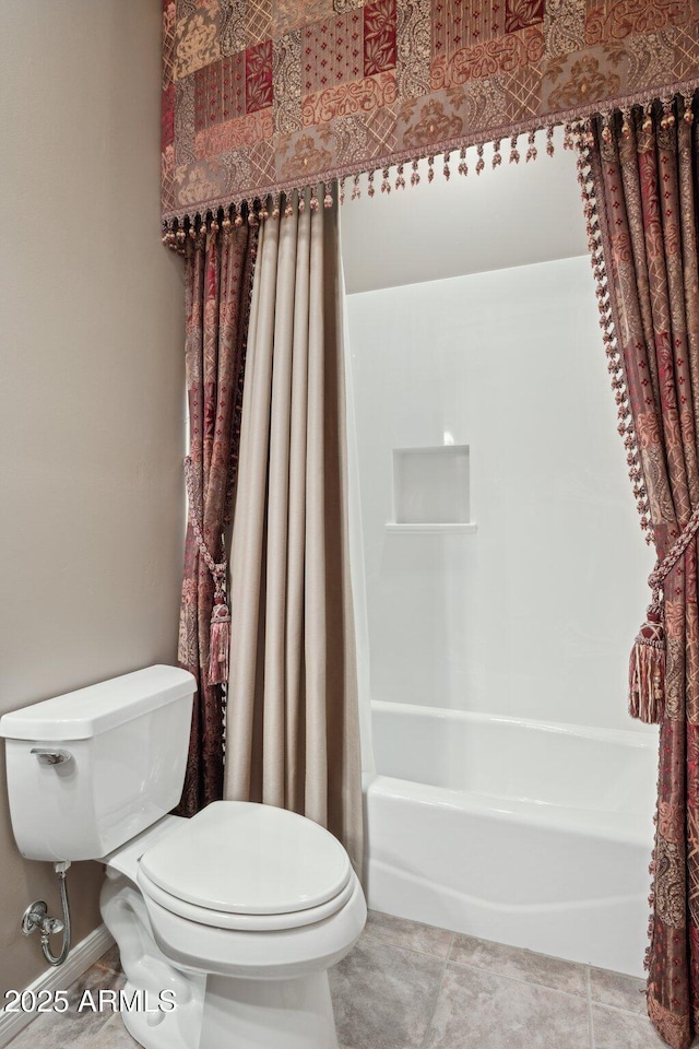 bathroom featuring tile patterned flooring, shower / bath combo, and toilet