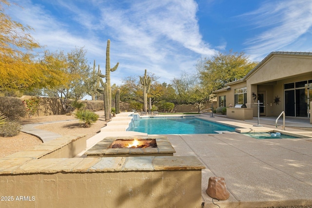 view of swimming pool featuring a fire pit and a patio area