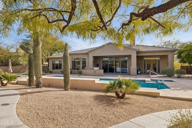 back of property featuring area for grilling, a fenced in pool, and a patio