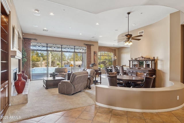 carpeted living room with ceiling fan with notable chandelier