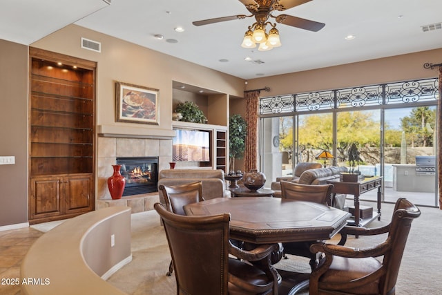 dining room featuring ceiling fan, built in features, and a fireplace