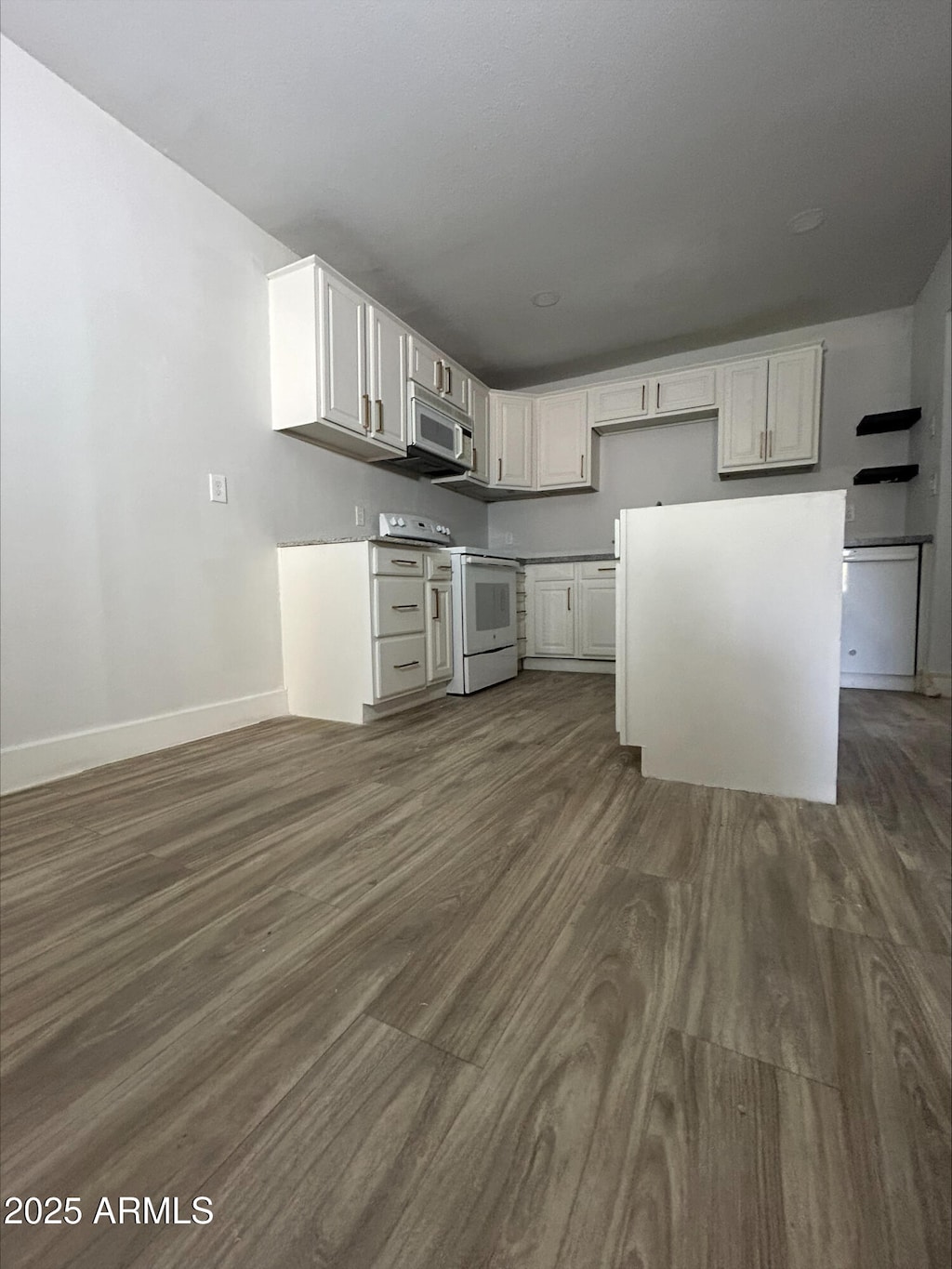 kitchen with baseboards, white electric range oven, dark wood-style floors, and white cabinetry