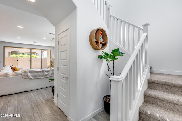 stairs with visible vents, baseboards, and recessed lighting