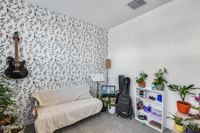 sitting room with wallpapered walls, carpet flooring, and visible vents