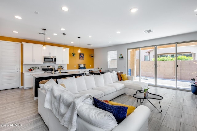 living room featuring visible vents and recessed lighting