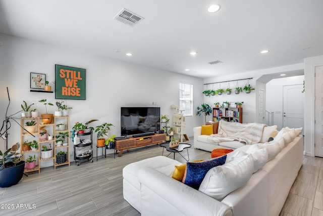 living area featuring visible vents, recessed lighting, and wood tiled floor