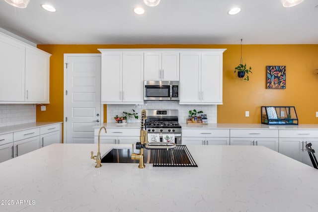 kitchen with recessed lighting, decorative backsplash, white cabinetry, and stainless steel appliances
