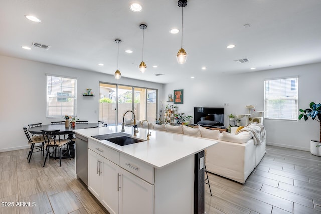 kitchen featuring light countertops, dishwasher, visible vents, and a sink