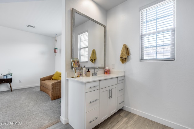 bathroom featuring visible vents, baseboards, and vanity