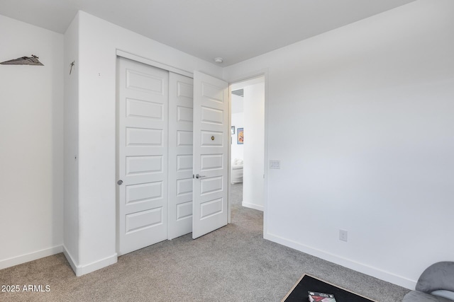 unfurnished bedroom with a closet, baseboards, and carpet floors