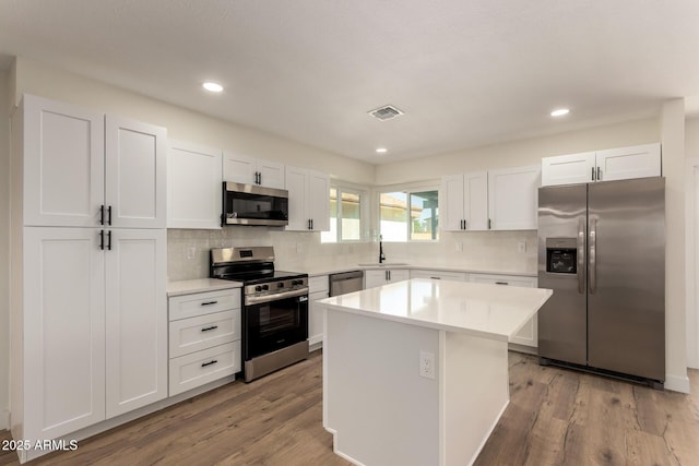 1521 W Jacinto Ave, Mesa, AZ 85202 - kitchen with appliances with stainless steel finishes, white cabinetry, backsplash, a center island, and light countertops