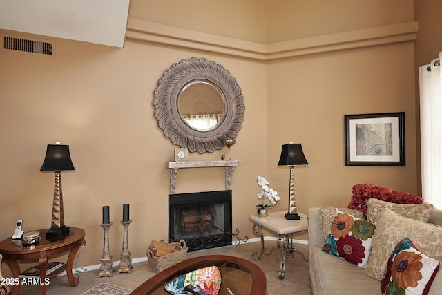 living room featuring a fireplace, visible vents, and baseboards