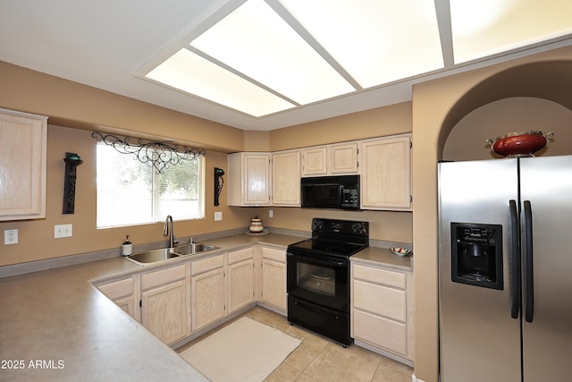 kitchen with light tile patterned floors, light countertops, light brown cabinetry, black appliances, and a sink