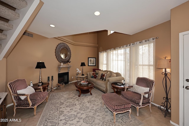 living area with lofted ceiling, light tile patterned flooring, recessed lighting, a fireplace, and visible vents