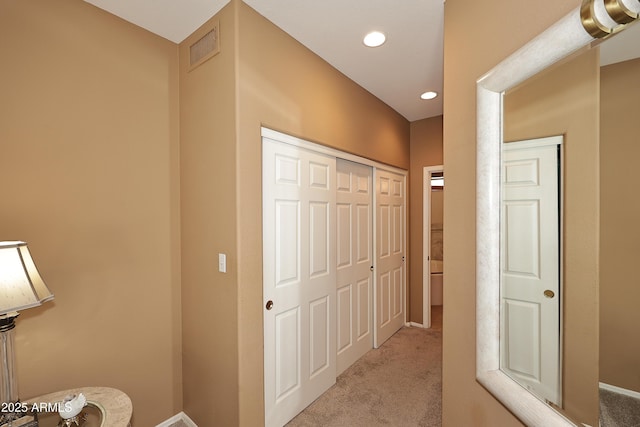 hall featuring light carpet, baseboards, visible vents, and recessed lighting