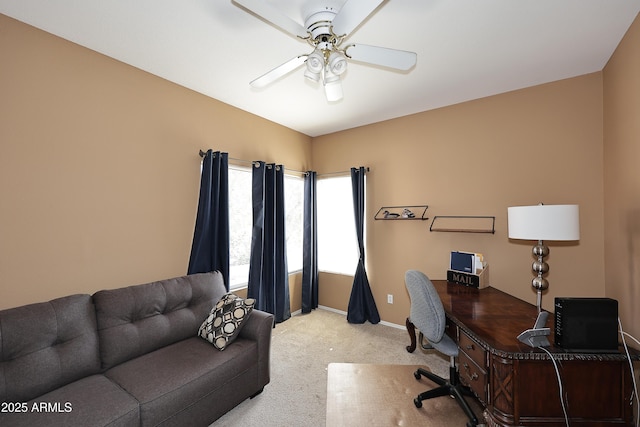 carpeted office with a ceiling fan and baseboards