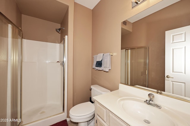 bathroom with a stall shower, vanity, and toilet