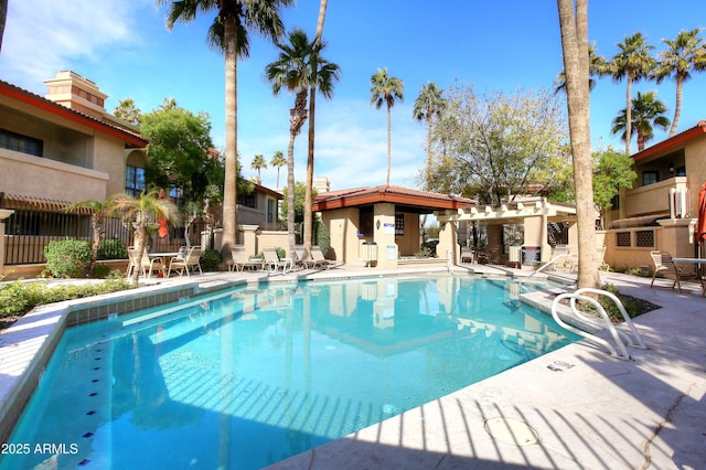 community pool with a patio area and fence