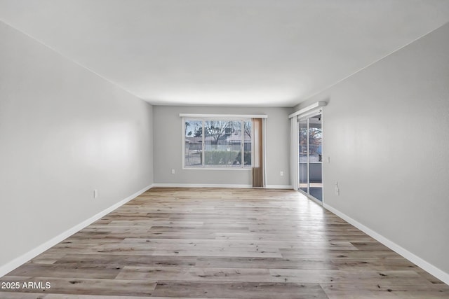 unfurnished room with baseboards and wood finished floors