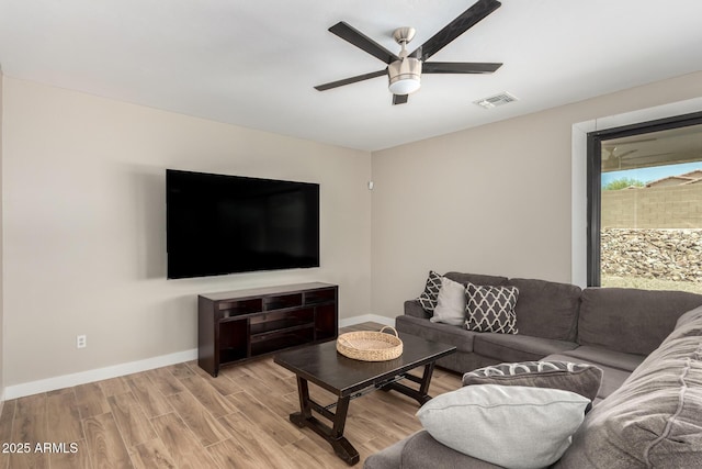 living area featuring light wood-style flooring, baseboards, a ceiling fan, and visible vents