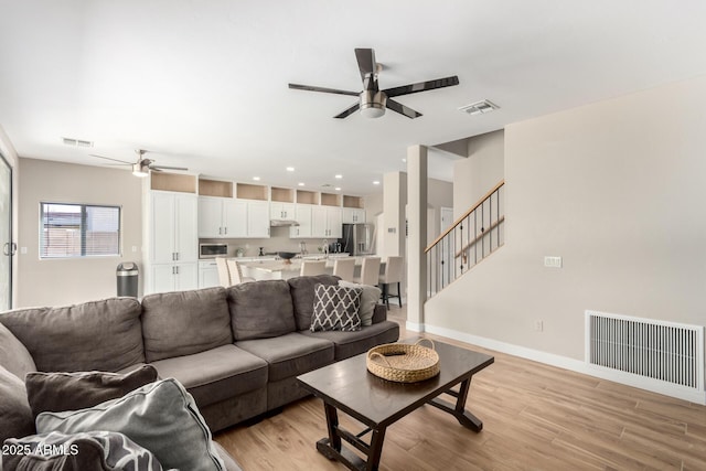 living room featuring visible vents and a ceiling fan