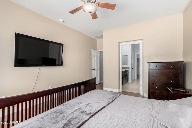 bedroom with ceiling fan, ensuite bathroom, baseboards, and visible vents