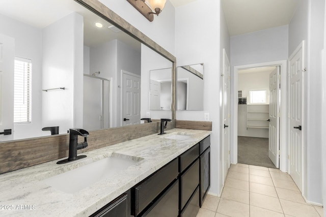 bathroom with a sink, a shower stall, plenty of natural light, and tile patterned floors