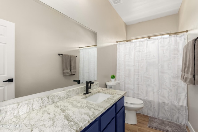 full bathroom featuring toilet, wood finished floors, a shower with shower curtain, visible vents, and vanity