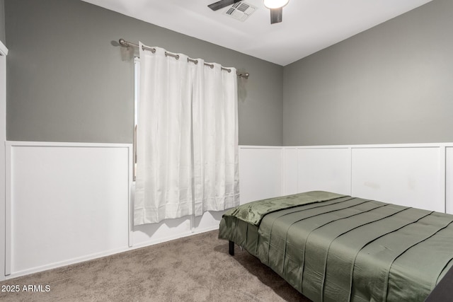 carpeted bedroom featuring a ceiling fan and visible vents