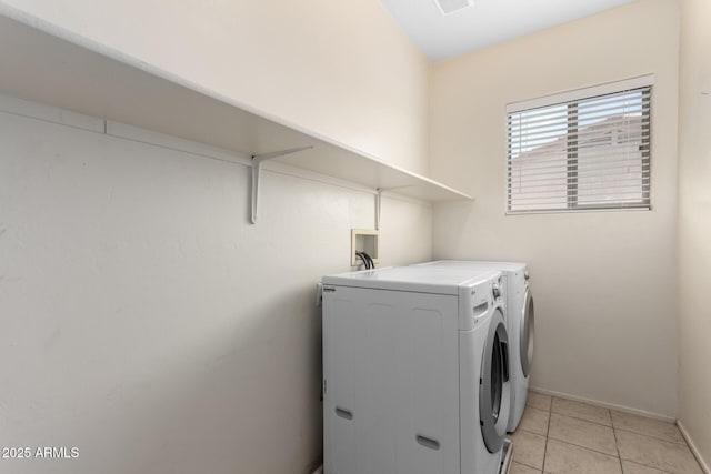 laundry area with washer and dryer, laundry area, light tile patterned floors, and baseboards