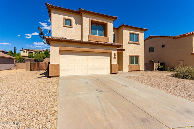 view of front of house with concrete driveway, stucco siding, an attached garage, and fence