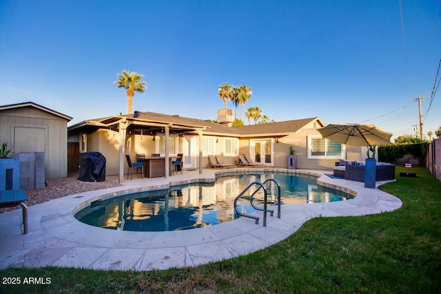 view of swimming pool featuring a patio area, a storage unit, and outdoor lounge area