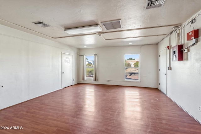 spare room featuring wood-type flooring and a textured ceiling