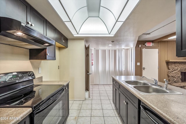 kitchen featuring stainless steel dishwasher, black electric range oven, light tile patterned floors, and sink