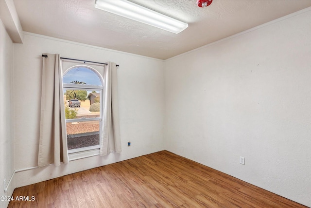 spare room featuring hardwood / wood-style flooring and crown molding