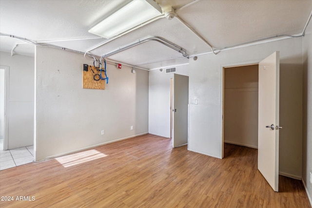 basement with light hardwood / wood-style flooring