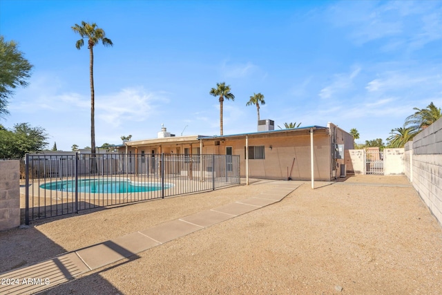 rear view of property featuring a patio area and a community pool