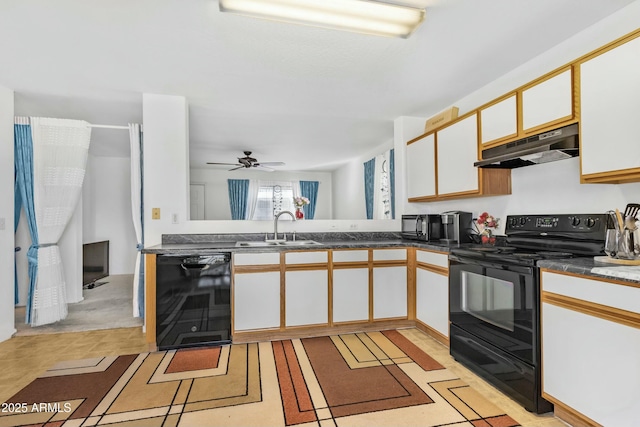 kitchen with dark countertops, under cabinet range hood, black appliances, white cabinetry, and a sink