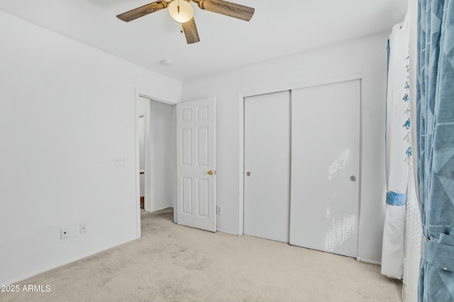 unfurnished bedroom with light carpet, ceiling fan, and a closet