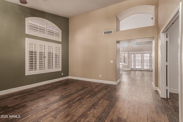 foyer featuring dark wood-type flooring, french doors, ceiling fan, and a high ceiling