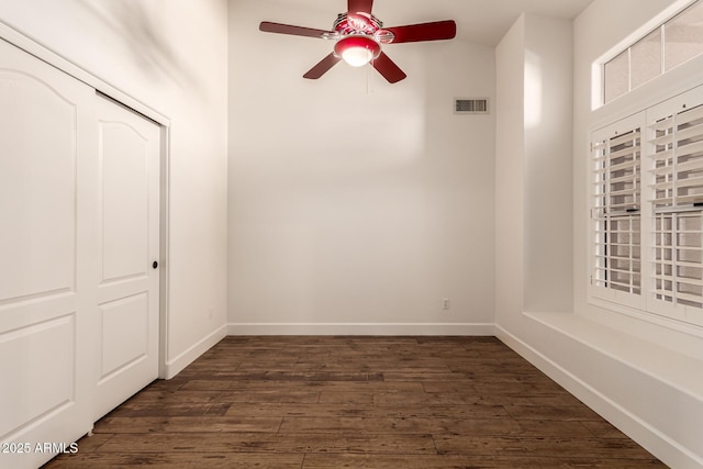 unfurnished bedroom featuring ceiling fan, dark hardwood / wood-style flooring, and a closet