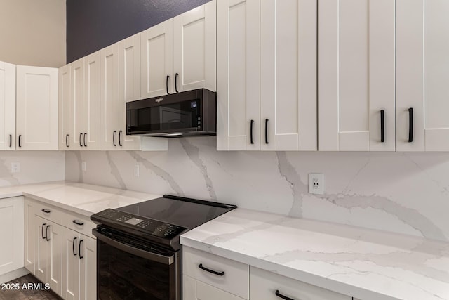 kitchen featuring white cabinetry, light stone counters, and black appliances