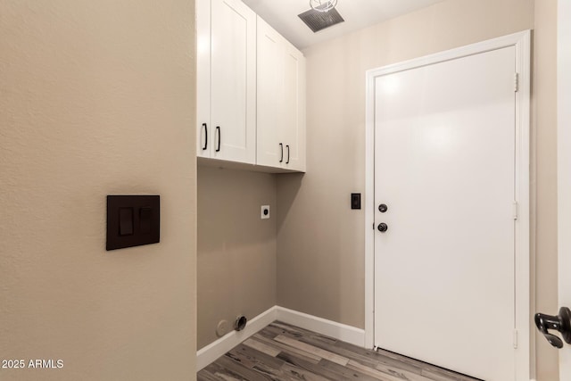 laundry area featuring cabinets, wood-type flooring, and hookup for an electric dryer