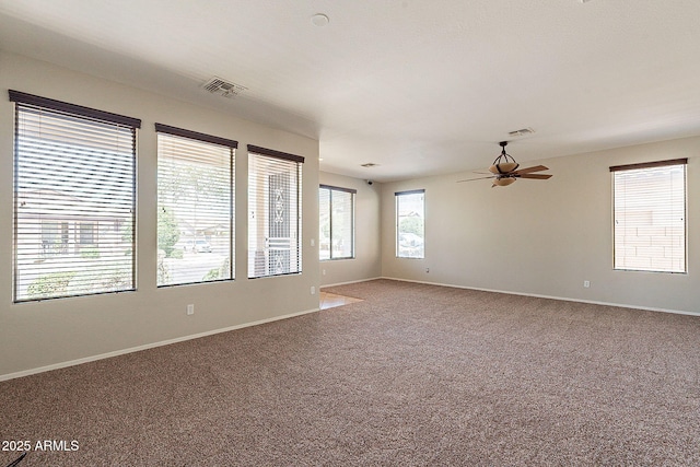 spare room with ceiling fan, visible vents, and carpet flooring