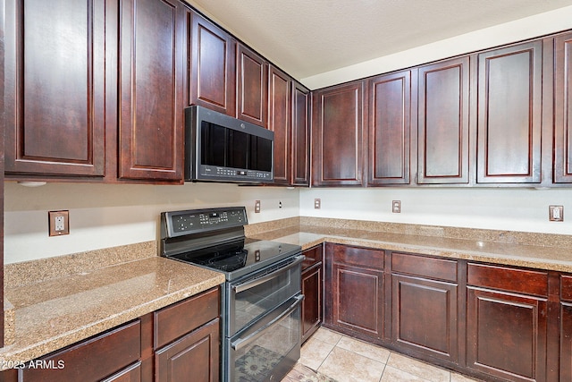 kitchen featuring range with two ovens, dark brown cabinetry, and light tile patterned floors